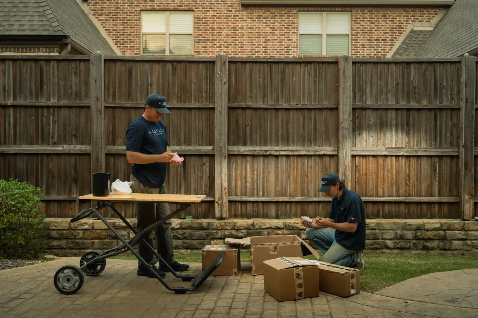 K Legacy Lighting crew unboxing fixtures at a job site