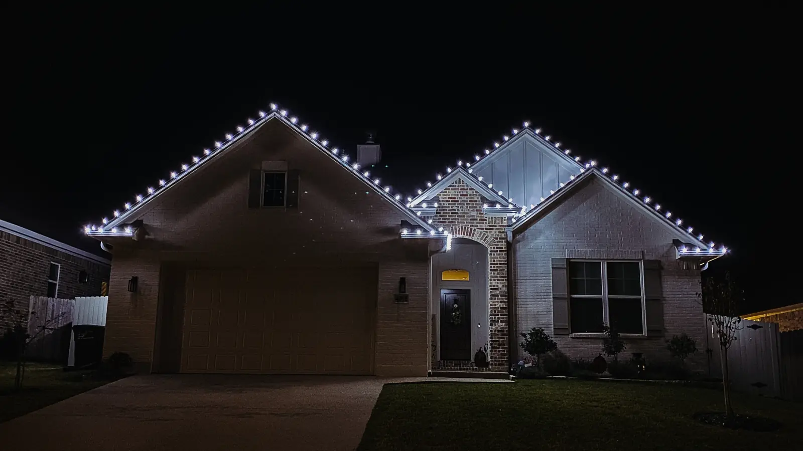 Holiday lighting along the roofline and gables of a North Texas home