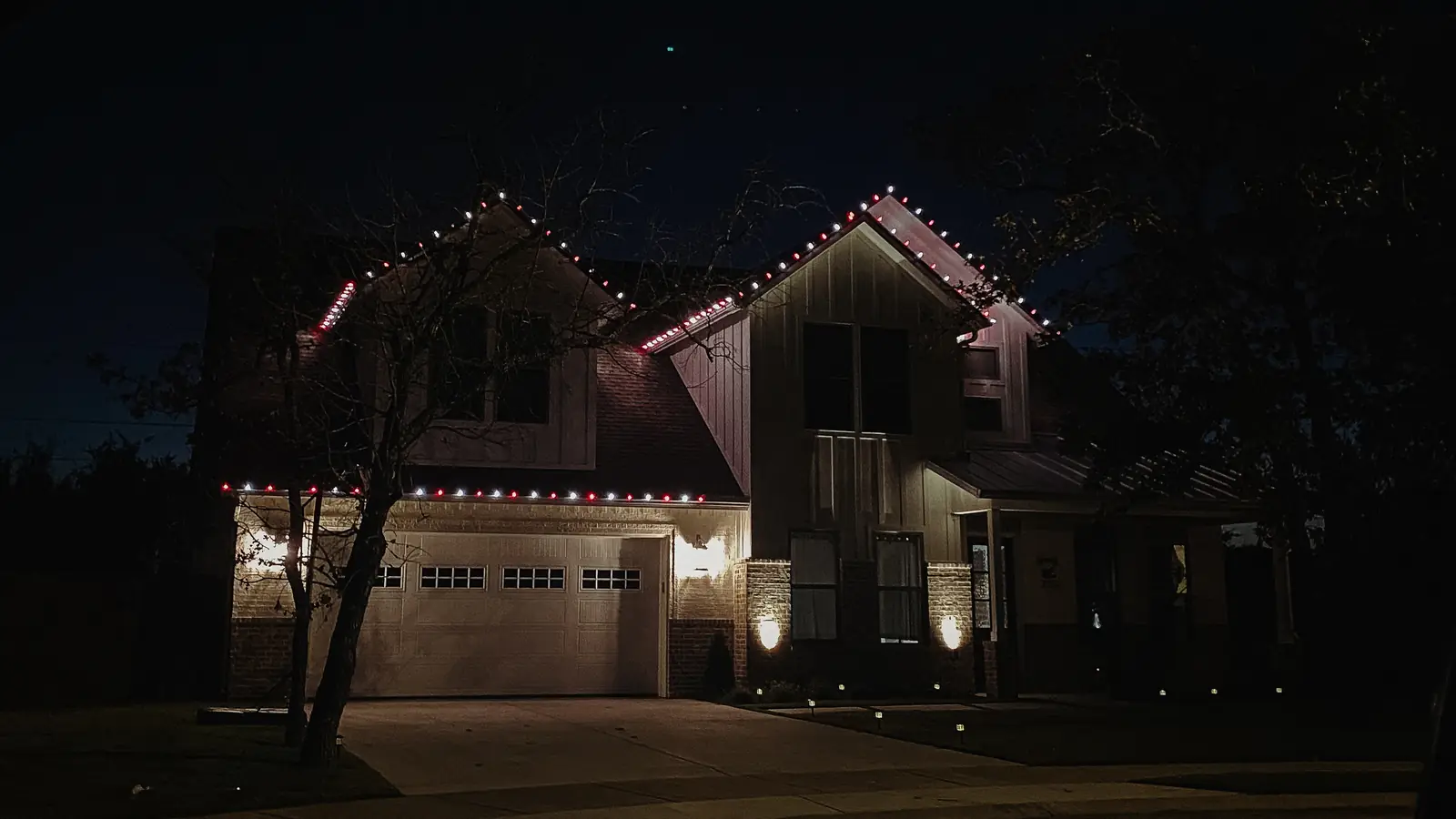Red and white Christmas lights outlining a roofline and dormers