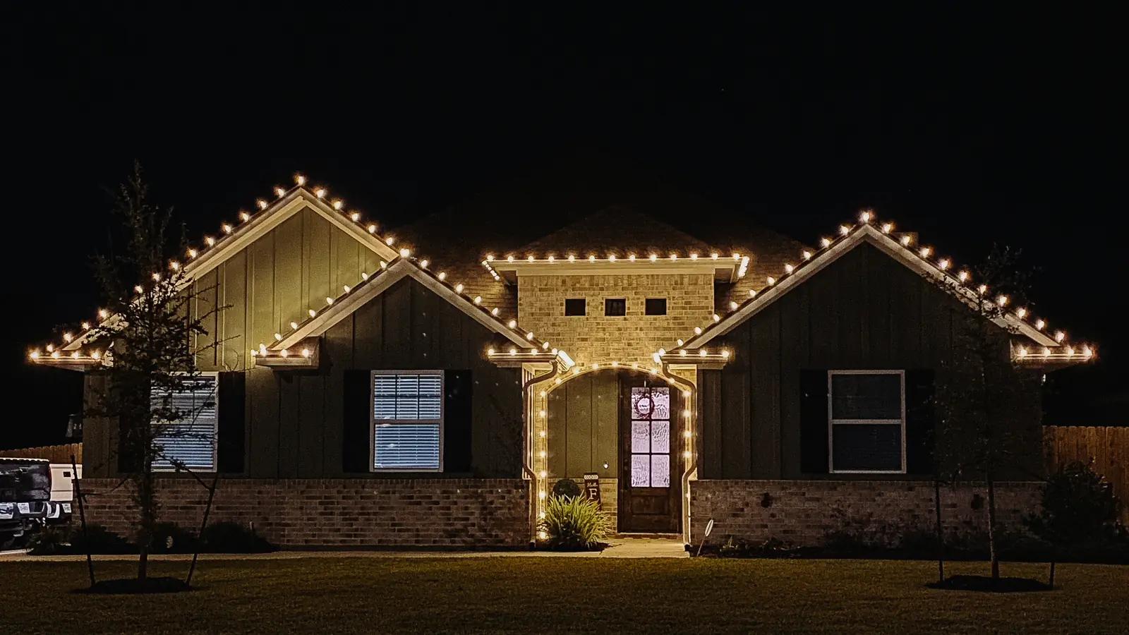 Warm white Christmas lights along the roofline of a North Texas home